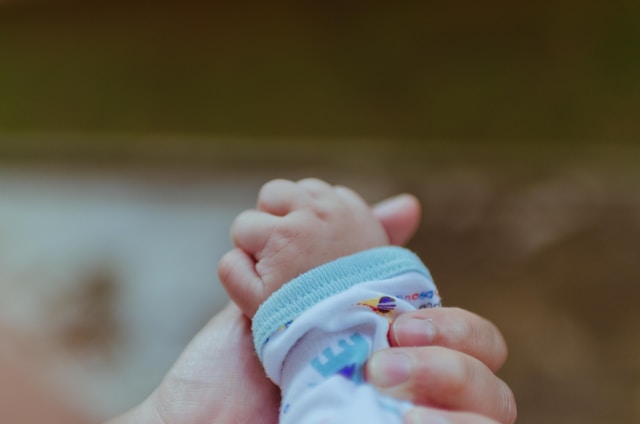 Ręga noworodka zaciśnięta wokół palca dorosłej osoby